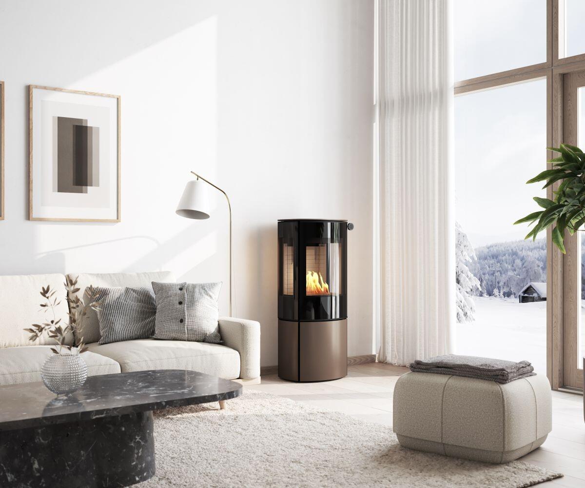 Rais Caro 110 Bio rounded bio stove by a marble coffee table with a snowy view