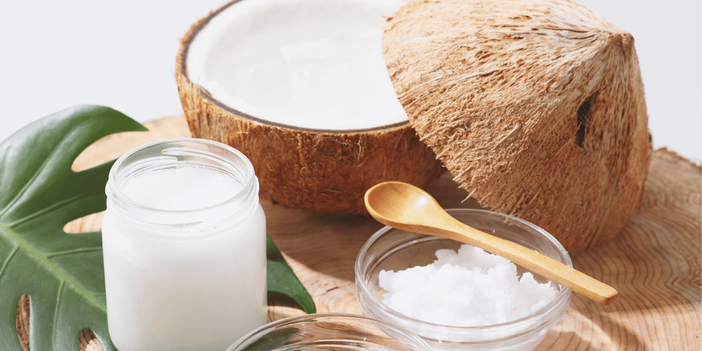 Natural deodorant ingredients including coconut oil, mineral salts and botanical skincare elements on a wooden surface.