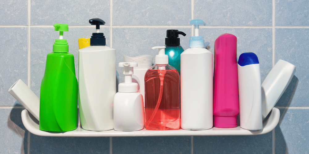 Bathroom shelf displaying everyday personal care products including toothpaste, shampoo, deodorant, moisturiser and cosmetics, illustrating common sources of chemical exposure.
