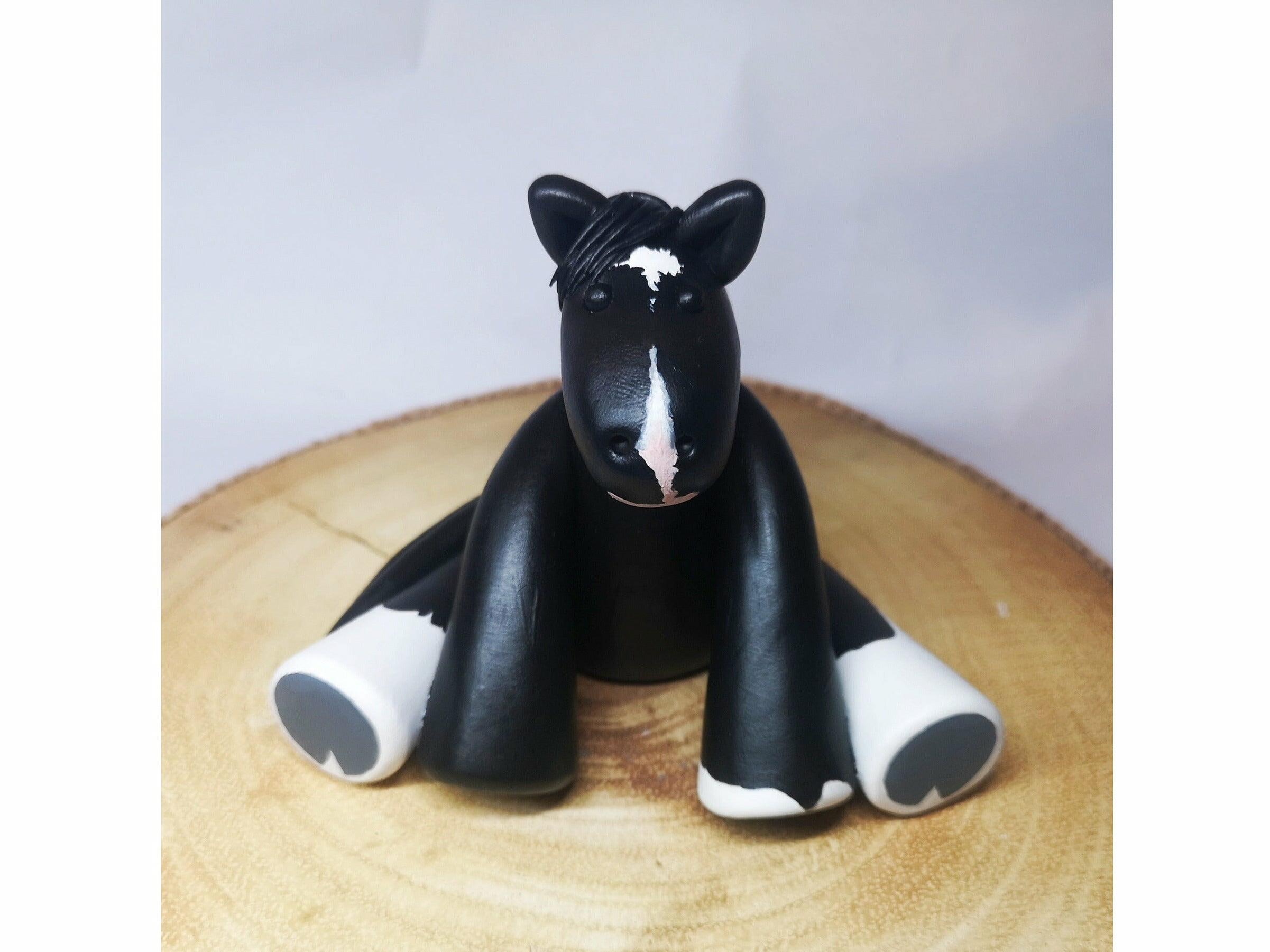 A clay model of a gypsy cob painted in black and white