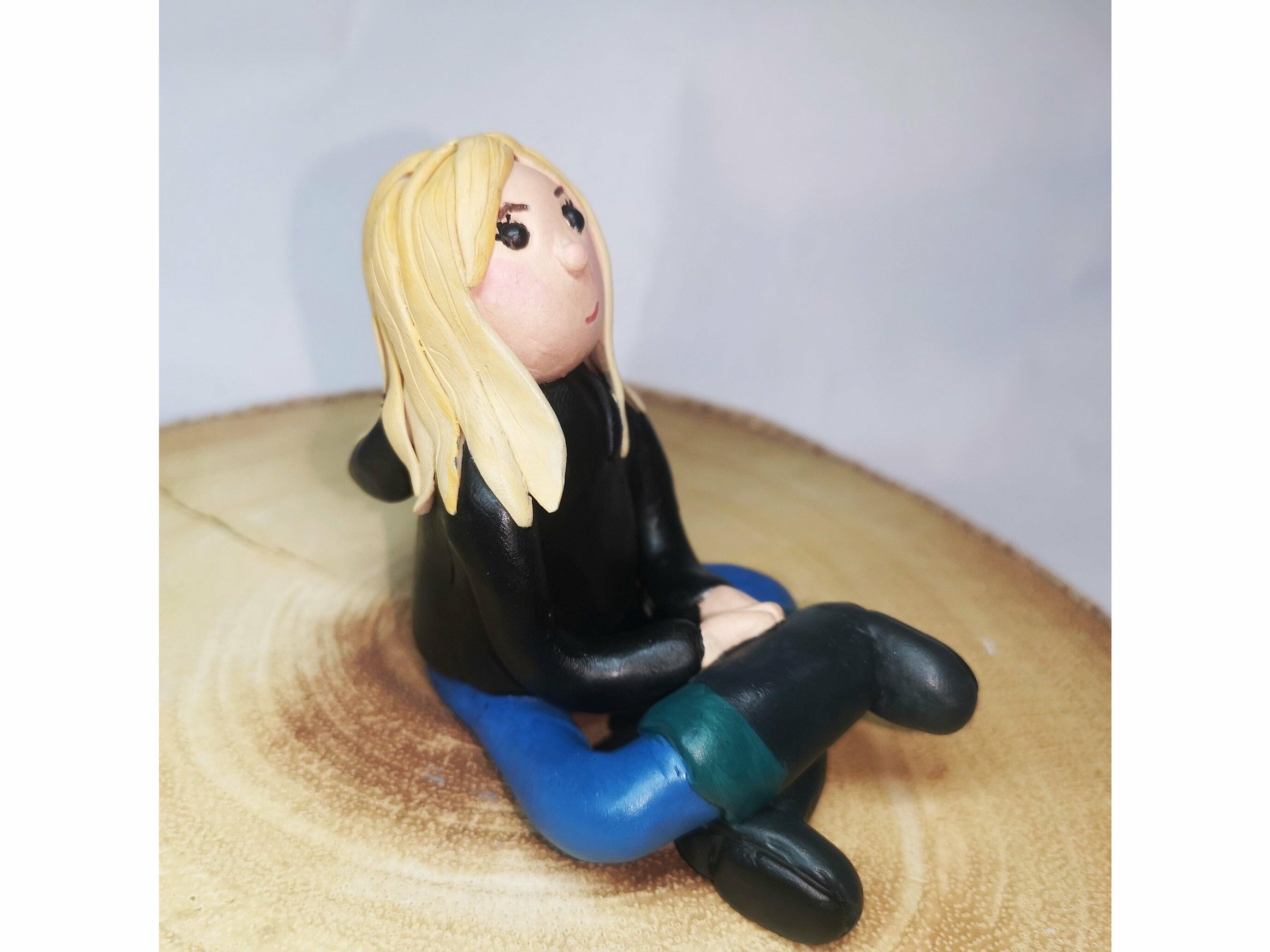 A side profile of a clay model of a young blonde girl wearing a hoody and wellington boots
