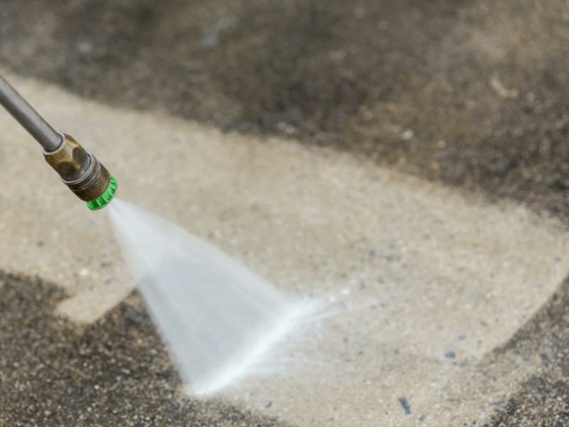 Pressure Washer Hose and Nozzle with a water jet cleaning an outdoor space