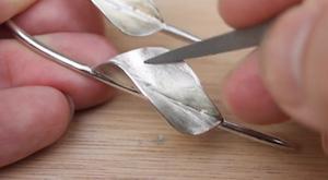 Using a steel needle file to remove excess solder, snags and burrs on silver