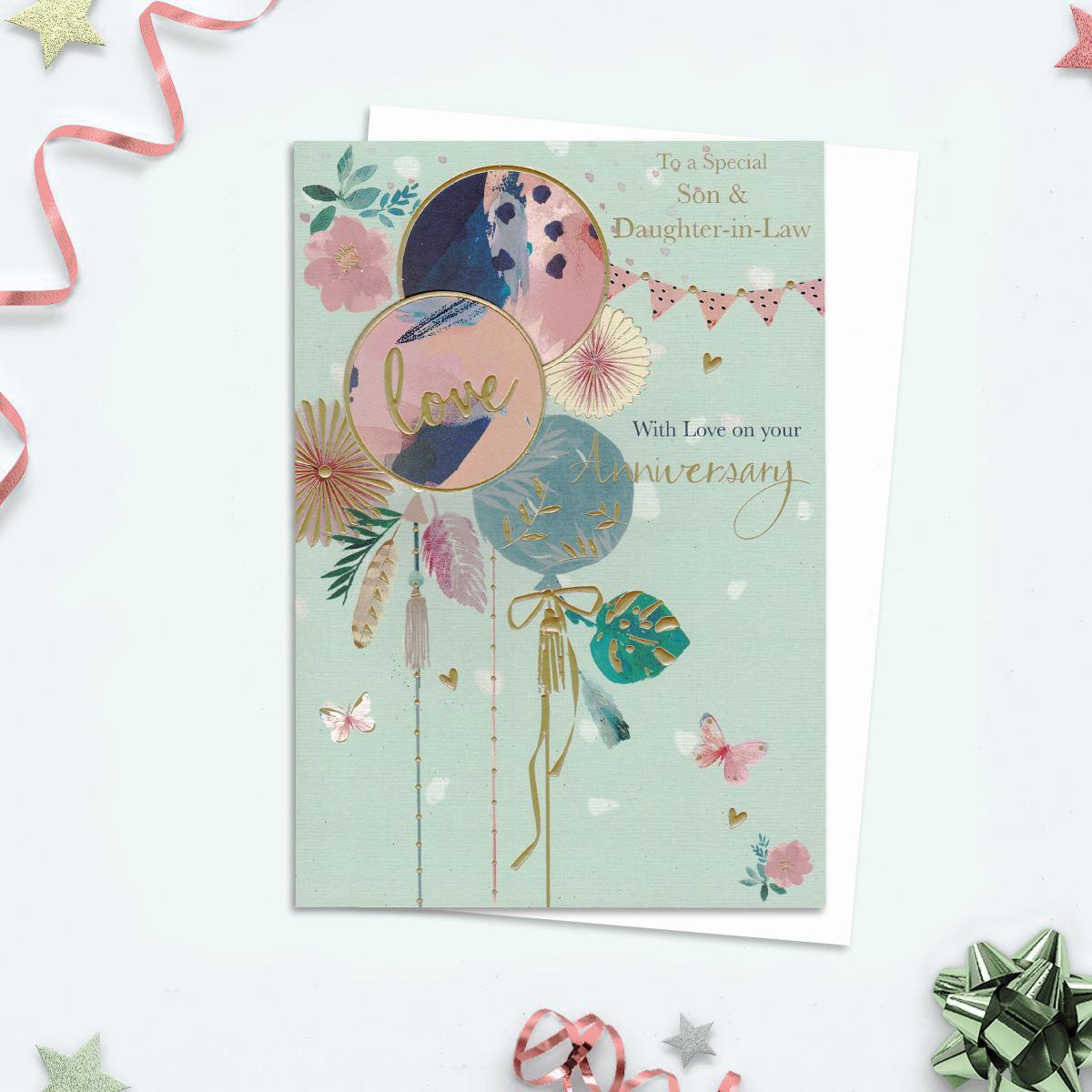 To A Special Son And Daughter In Law With Love On Your Anniversary Card . Depicting Pastel Pinks And Green Colours With Gold Foil Accents. Balloons, Bunting, Flowers And Butterflies All Add To The Charm. Decoupage Element to The Front And Complete With A White Envelope