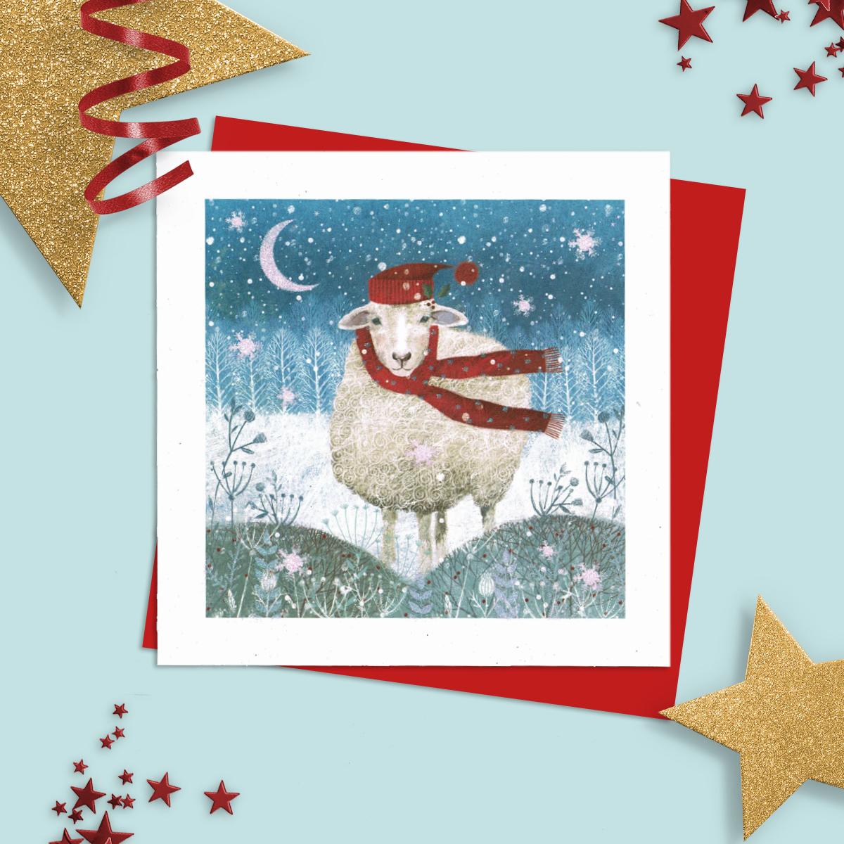 General Christmas Card Featuring A Sheep Out In The Snow Wearing Hat And Scarf! Finished With Added Sparkle And Red Envelope