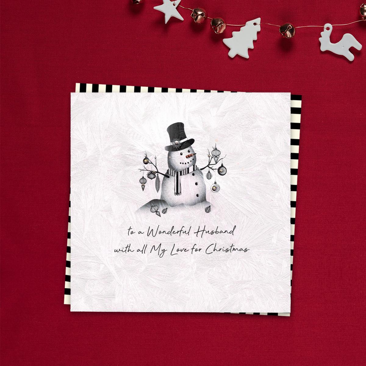 To A Wonderful Husband With All My Love For Christmas Featuring A Beatiful, Decorated snowman On A Background Of Shattered Ice! Finished With Jewel Embellishments, This Handcrafted Card Is Simply Stunning. Blank Inside For Your Own Message. White Envelope With Black Striped Border