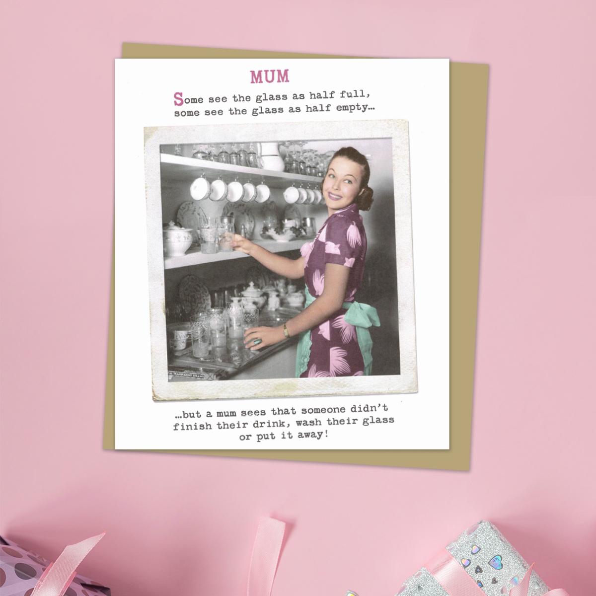Mothers Day Card With Retro Photographic Image Of a Woman At An Old Fashioned Dresser. Caption: Some See The Glass As Half Full, Some See The Glass As Half Empty... But A Mum Sees That Someone Didn't Finish Their Drink, Wash Their Glass Or Put It Away Again! Complete With Manila Envelope