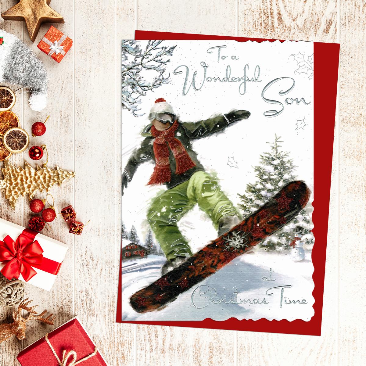 To A Wonderful Son At Christmas Time. A Young Man Snowboarding. Finished With Silver Foil lettering And Red Glitter. Complete With Red Envelope