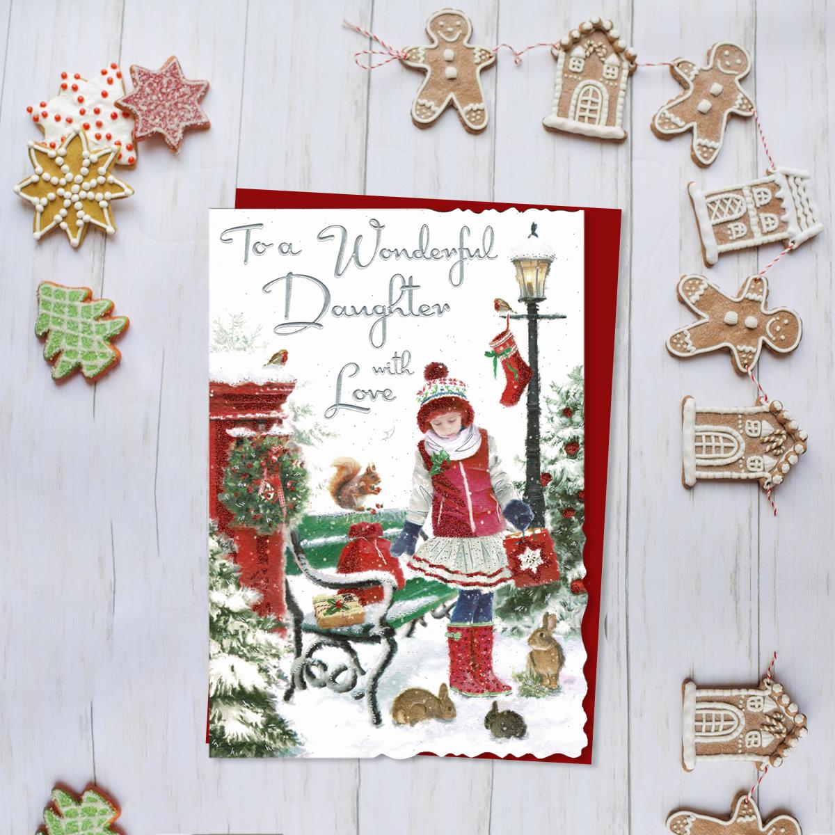 To A Wonderful Daughter With Love Featuring A Girl Surrounded By Woodland Animals In The Snow. Finished With Silver Foiled Lettering, Red Glitter Detail And Red Envelope