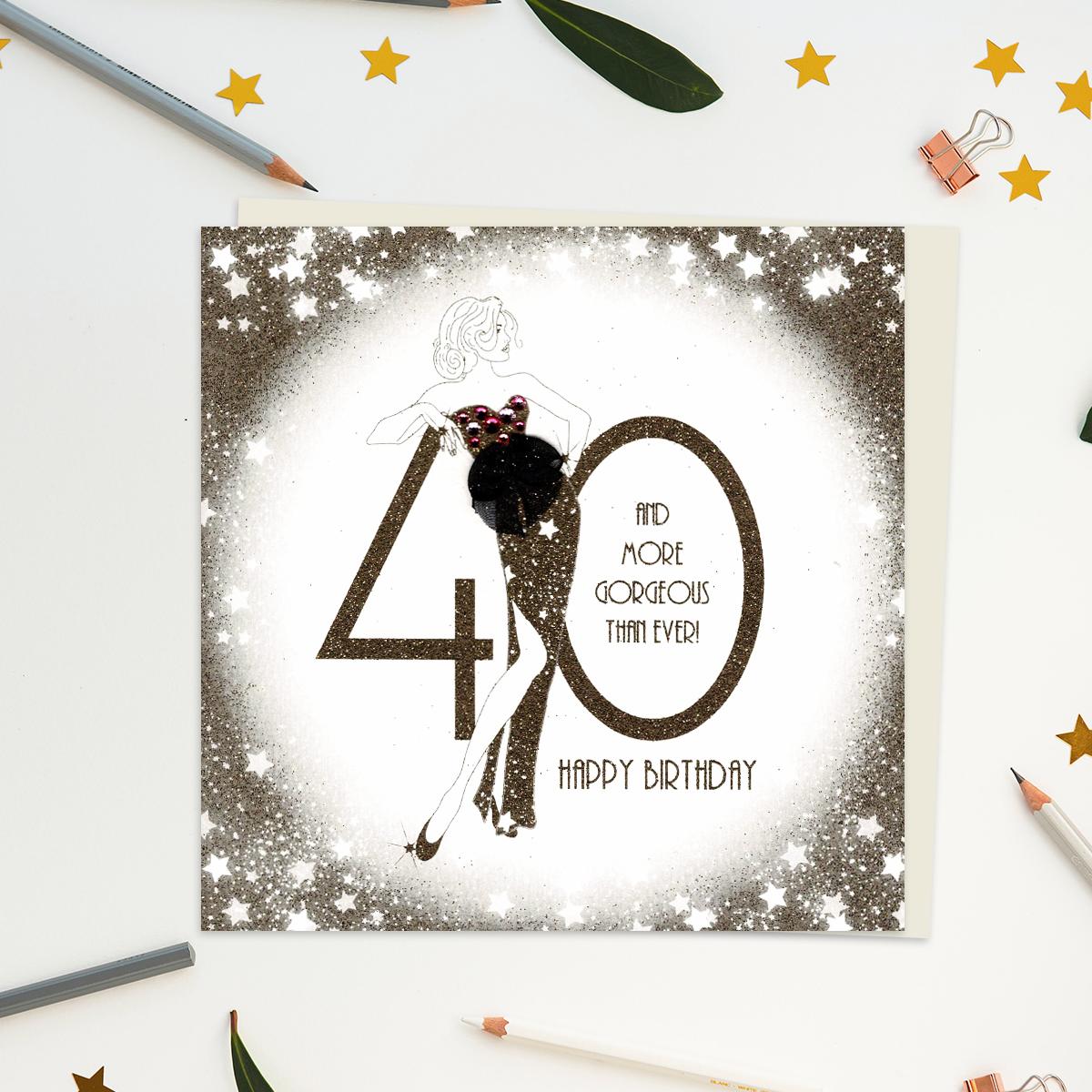 A stunning handcrafted card on embossed card showing a woman leaning on the number 40. Caption: 40 And More Gorgeous Than Ever! Happy Birthday. Gold Glitter Accents, Gem Embellishments And additional Attachments On This Luxury Design From Five Dollar Shake. Blank inside For Your Own Message. Complete With Ivory Envelope