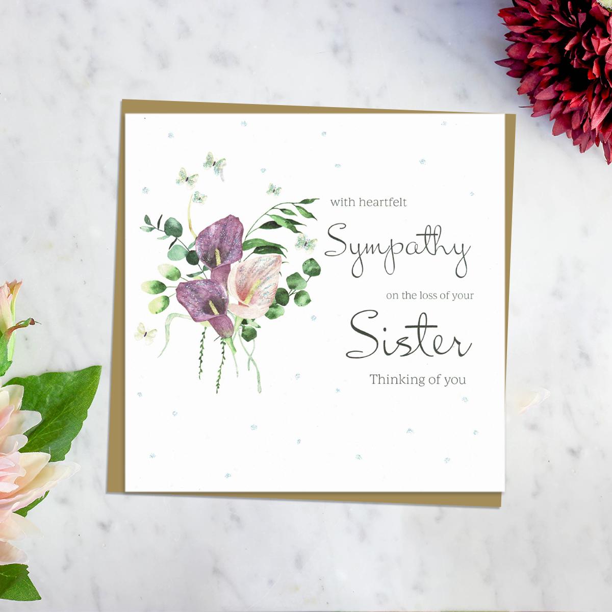 ' With Heartfelt Sympathy On The Loss Of Your Sister Thinking Of You' Card Featuring Beautiful Calla Lilies In Purple and Pink. With Discreet sparkle And Brown Envelope. Blank Inside For Own Message