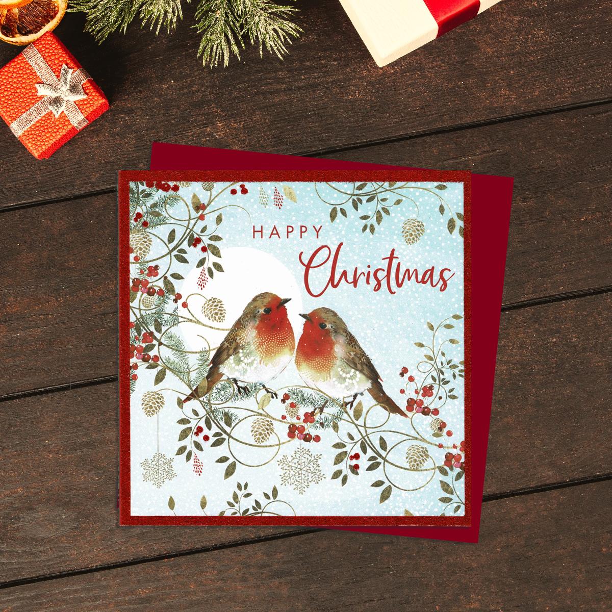 Happy Christmas Open Christmas Card Showing two Robins On A Branch Of Berries. Finished With Red Glitter. Complete With Red Envelope