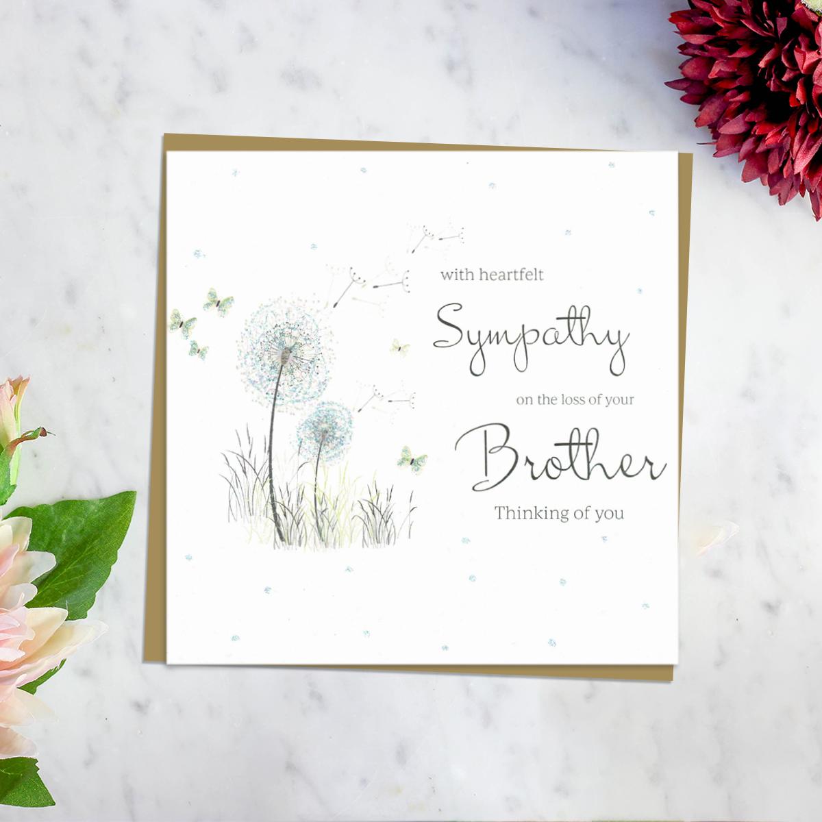 ' With Heartfelt Sympathy On The Loss Of Your Brother Thinking Of You' Card Featuring A Dandelion Blowing In The Wind Surrounded By Butterflies. With Discreet Sparkle and Brown Envelope. Blank Inside For Own Message