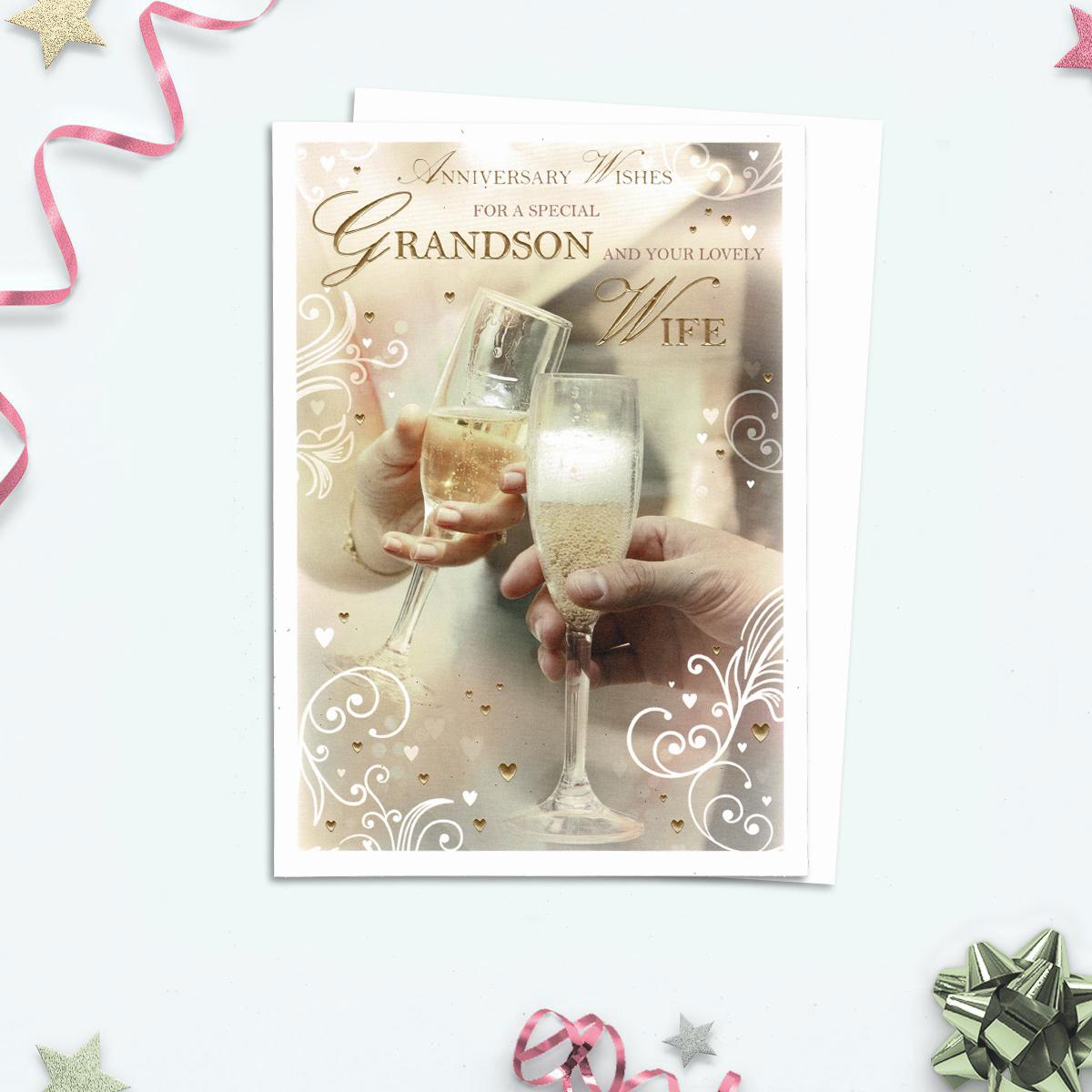 Anniversary Wishes For A Special Grandson And Your Lovely Wife Card Shows A Celebratory Champagne Toast In Muted Beige And Brown Colours With White Scrolling And Gold Foil Accents. Complete With White Envelope
