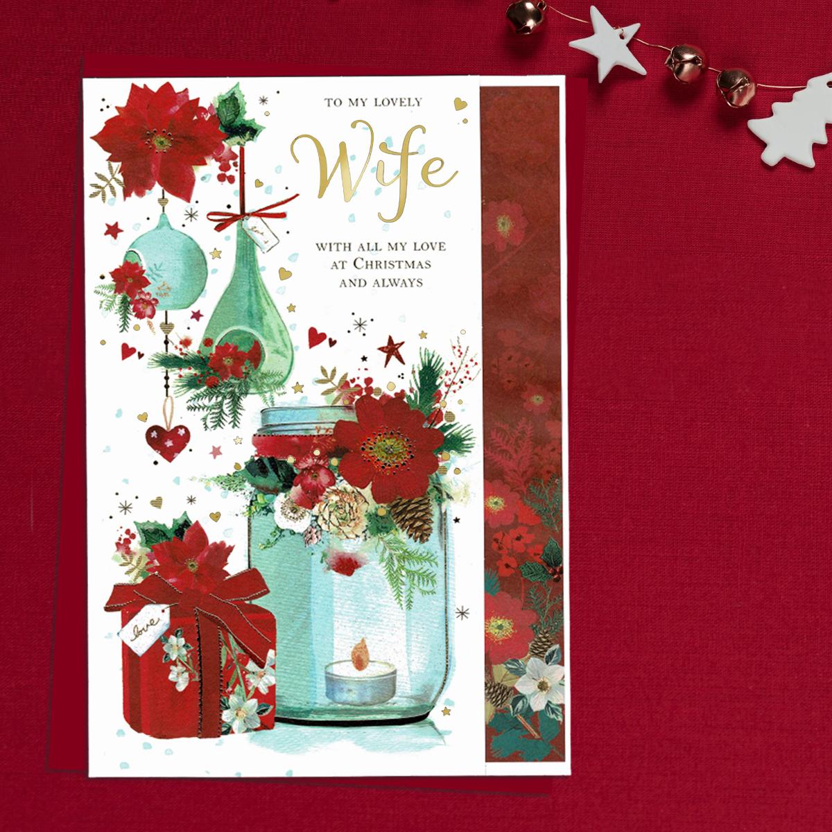A Festive Scene Showing Hurricane Lamp, Gifts, Baubles And Poinsettias Decorate This Wife Christmas Card. Finished With Gold Foil Lettering And Accents And Completed With a Red Envelope