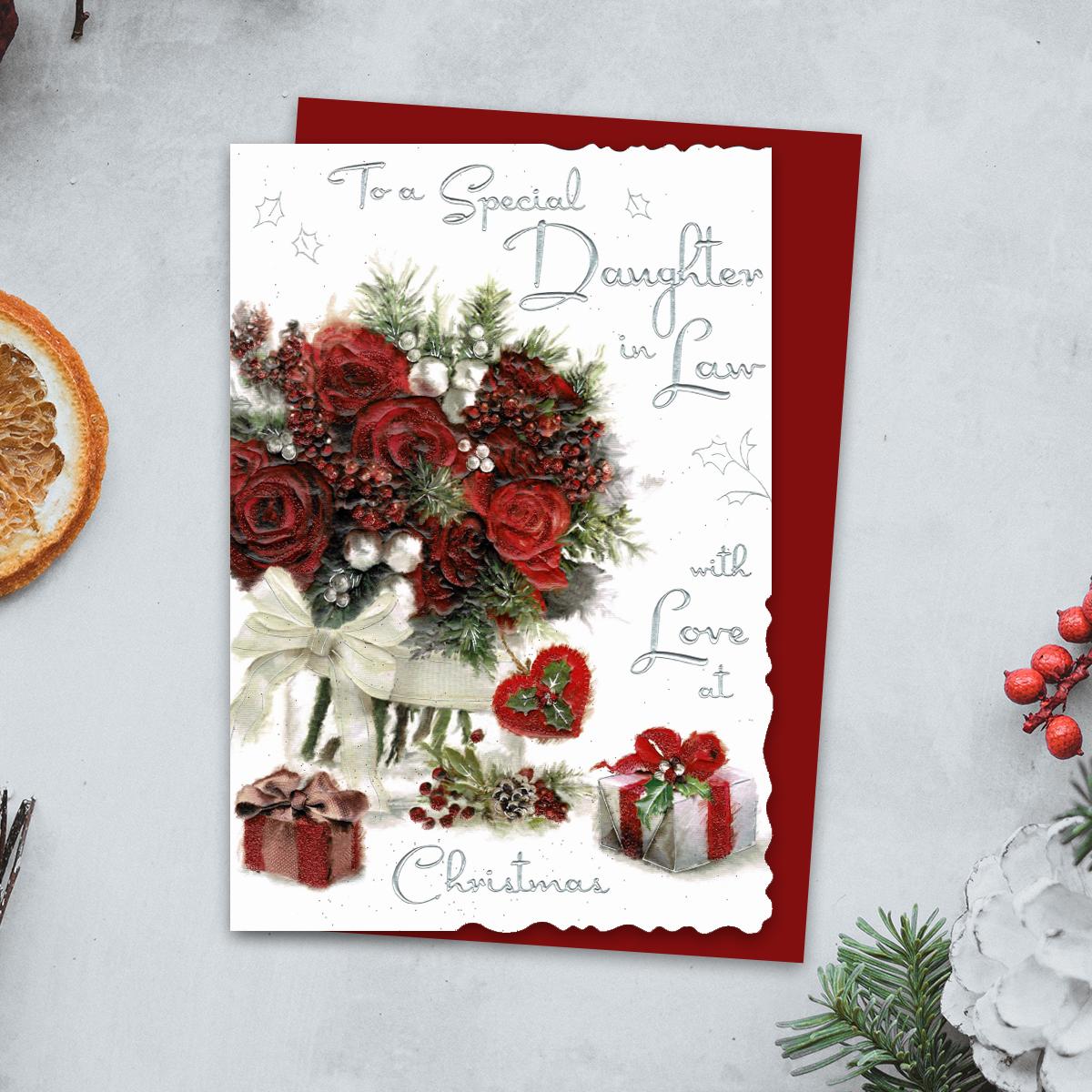 To A Special Daughter In Law With Love At Christmas Features Red Roses, Gifts And A Red Heart. Finished With Silver Foiled Lettering, Red Glitter Detail And Red Envelope