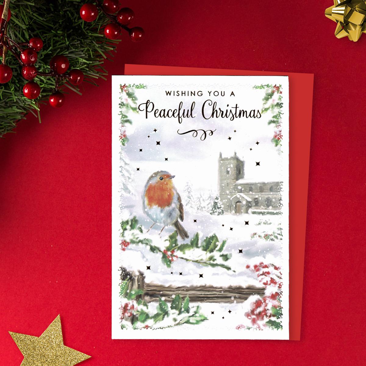 Wishing You A Peaceful Christmas Featuring A Robin In The Snow With Church in The Background. finished with Gold Foil Details And Red Envelope