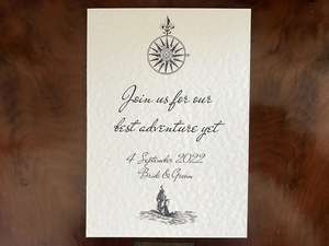 Ivory wedding invitation with compass and ship