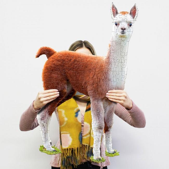Person holding up llama-shaped puzzle.