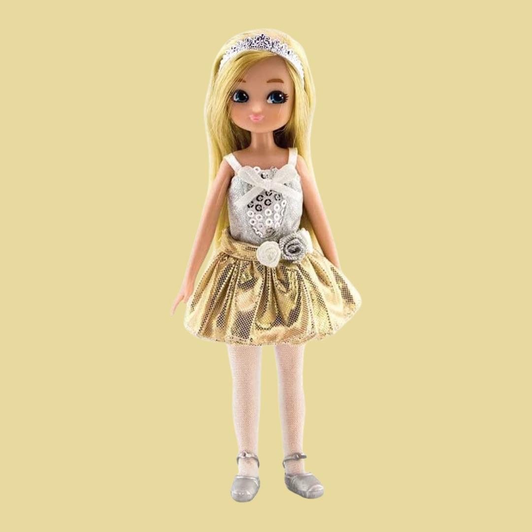 Swan Lake Lottie children's doll with blonde hair, gold tutu on a dull yellow background.