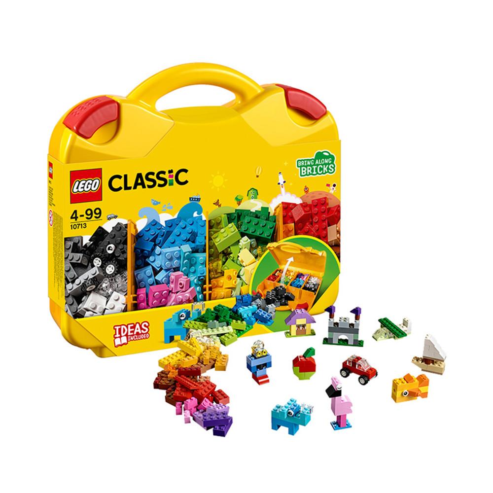Yellow plastic case with handle with classic colourful lego pieces in front. White background.