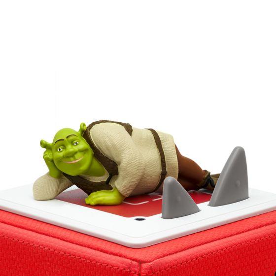 Green Shrek figure lying down on top of red Toniebox.