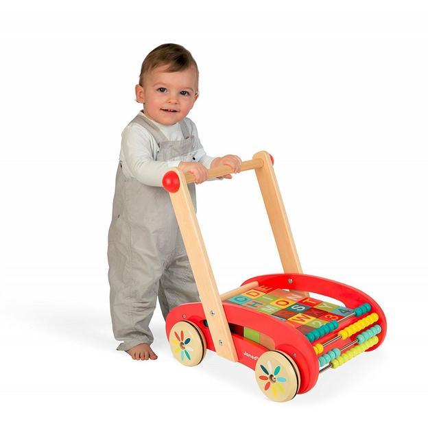Young child pushing a wooden baby walker