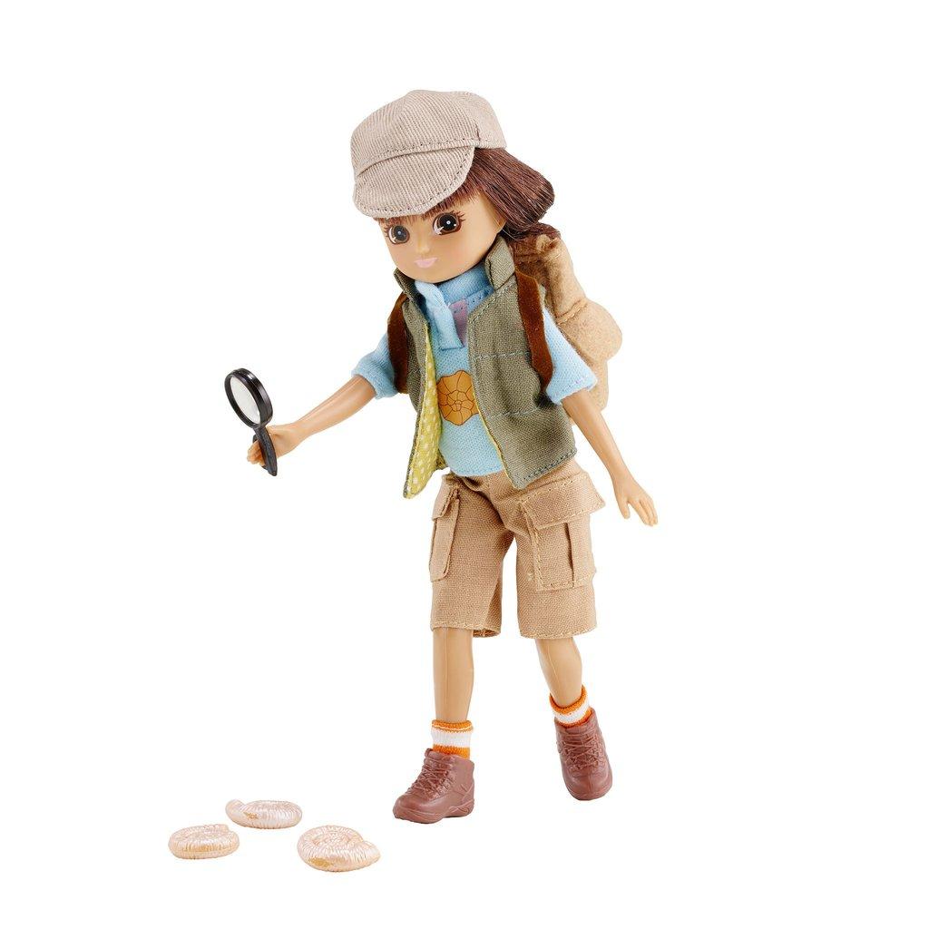 Lottie Doll standing, slightly bent over holding a magnifying glass and looking at 3 ammonites on the ground. White background.