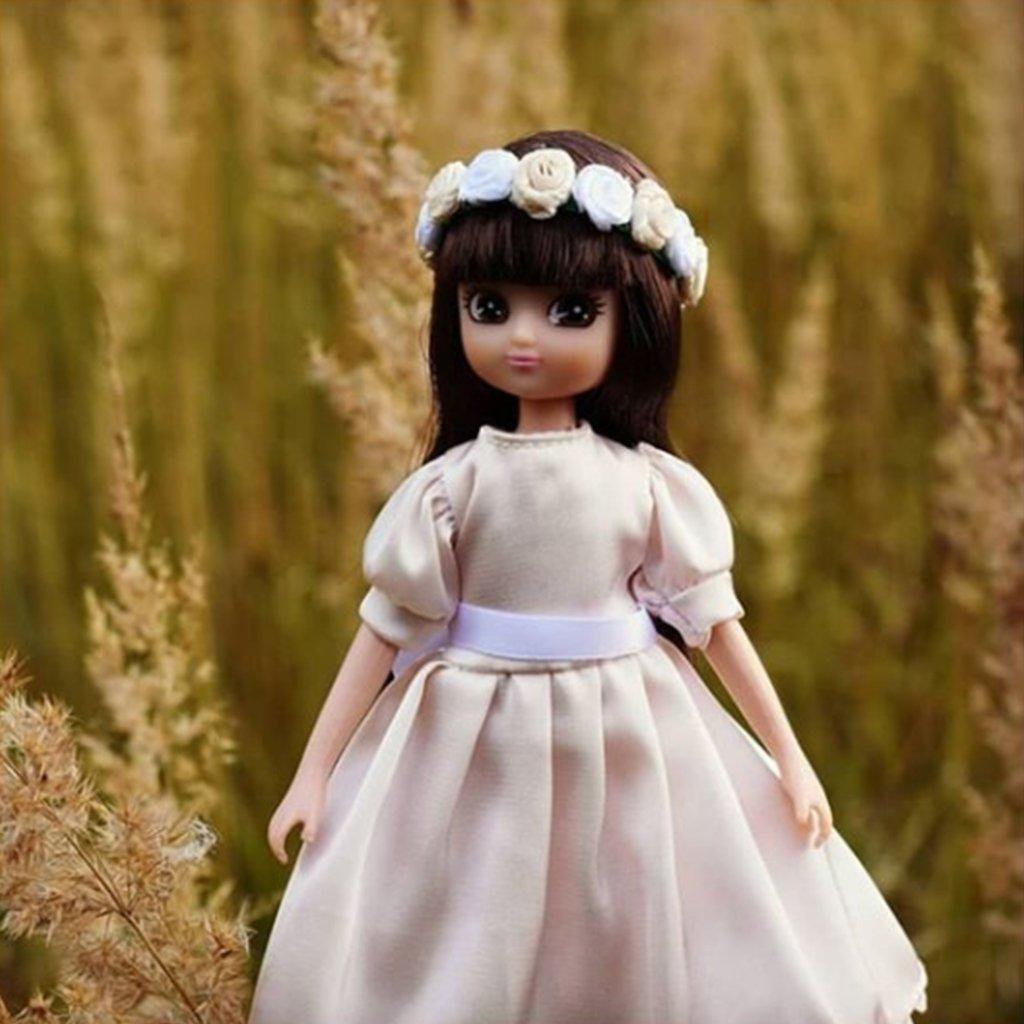 Lottie doll standing with a background of golden grass.