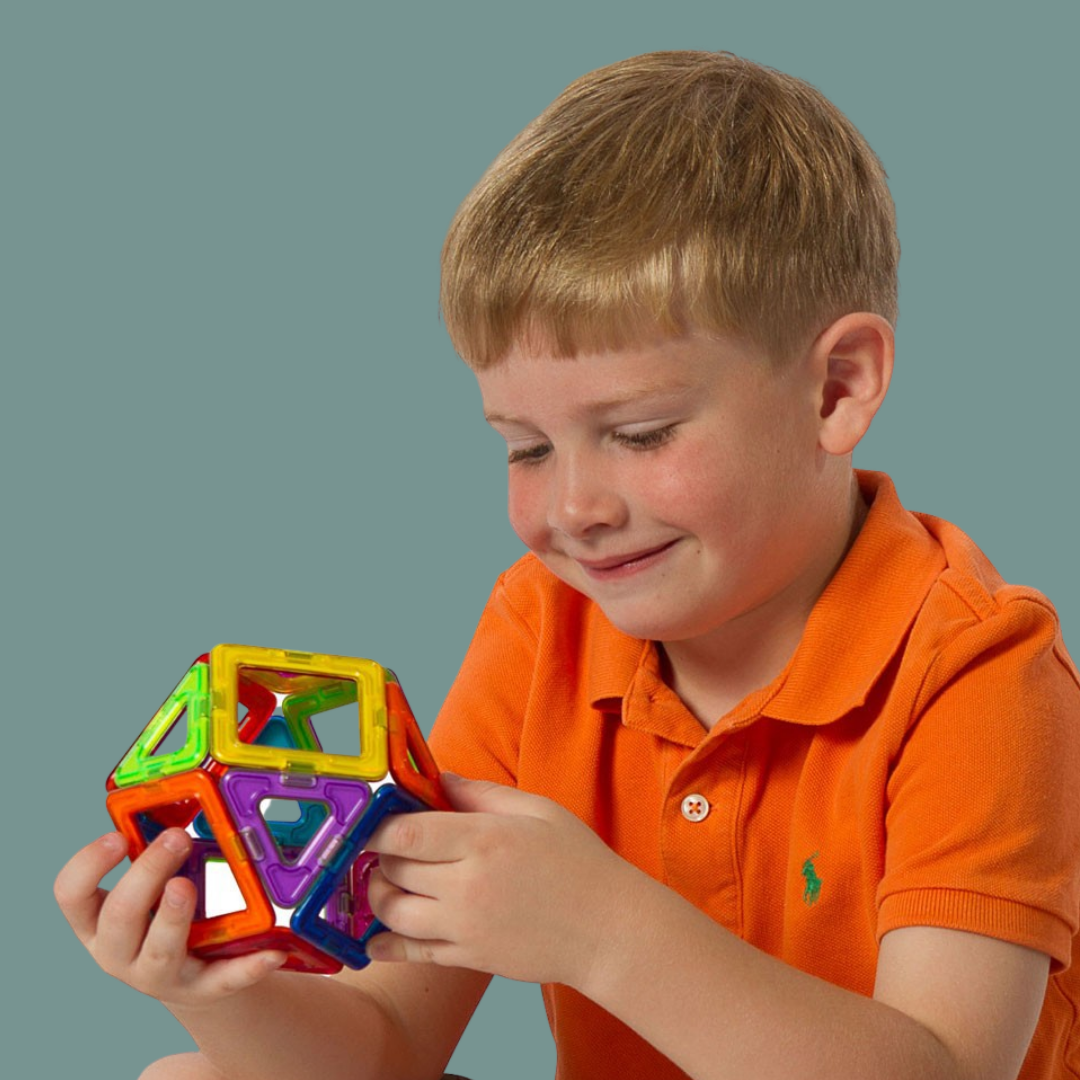 Boy playing with a colourful shape made outof Magformers.