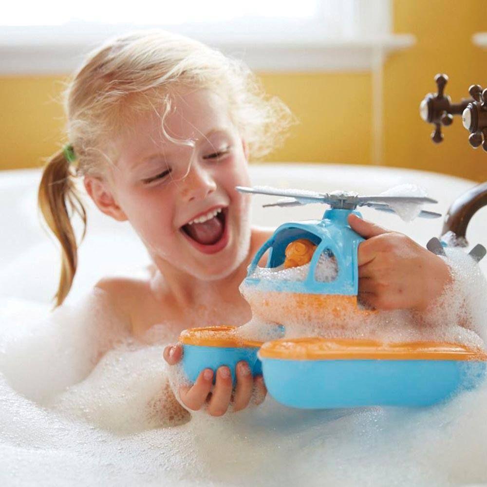 Kid playing with recycled plastic orange and blue seacopter in bubble bath.
