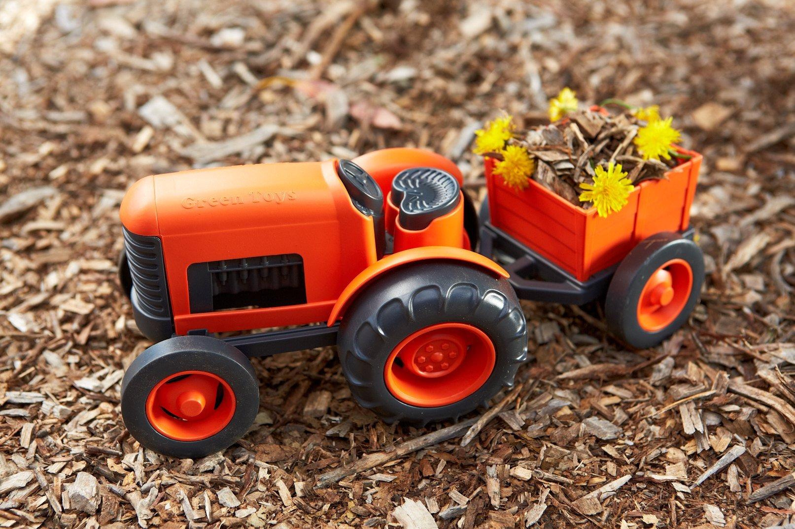 Orange tractor and trailer carrying flowers.