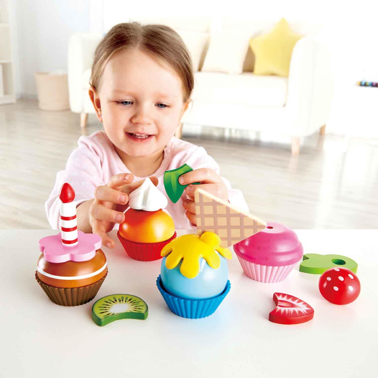Girl playing with cupcake pieces