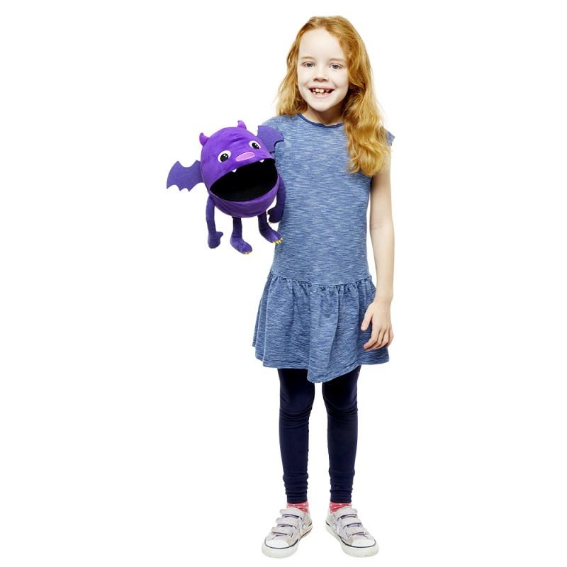 Girl holding purple monster hand puppet.