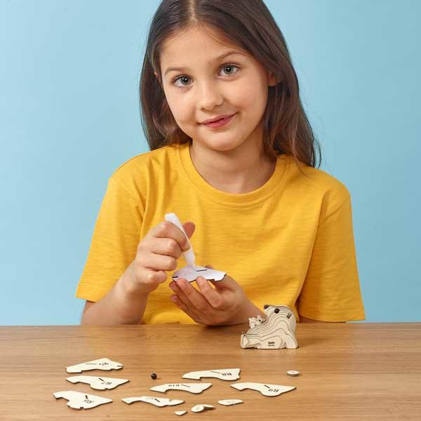 girl wearing a yellow tshirt sticking the pieces of the Eugy polar bear together.