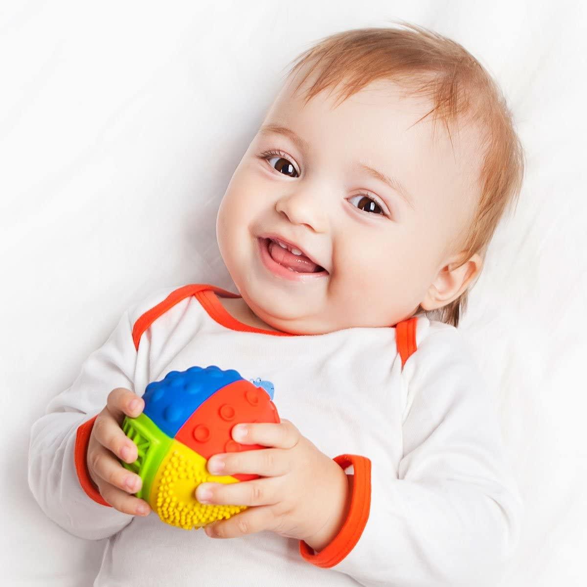 Baby lying down and holding a colourful ball