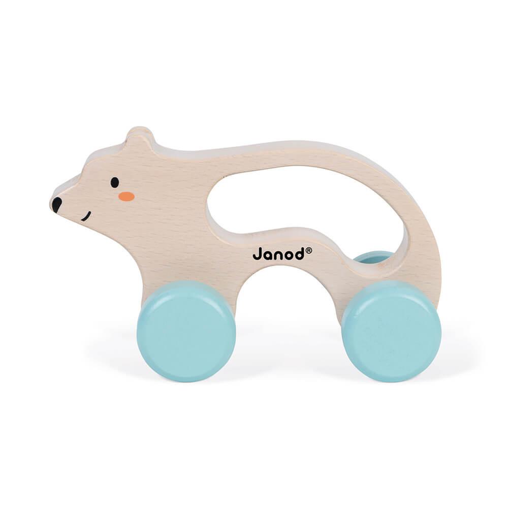 Side view of a wooden polar bear toy with handle and wheels. White background.