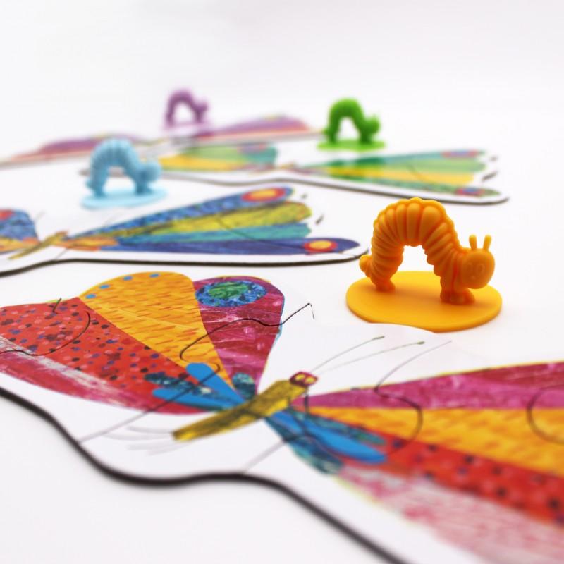 Parts of the board game showing a low view of the butterfly jigsaw parts and a yellow caterpillar.