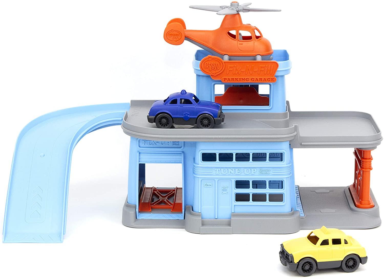 Toy parking garage with ramp, helicopter on helipad, a yellow taxi and blue police car all made from 100% recycled plastic.