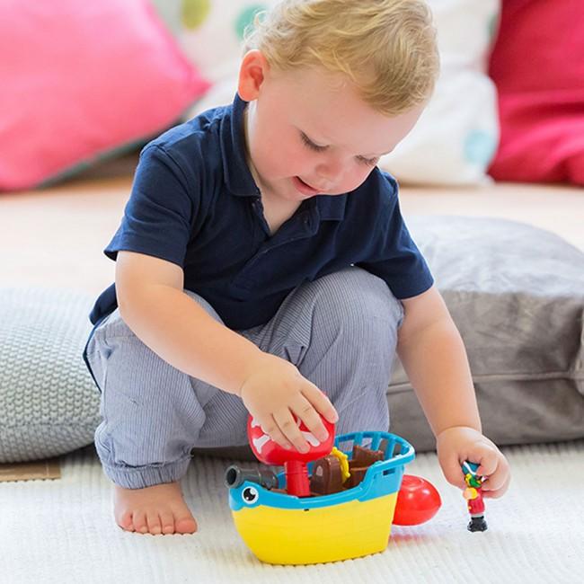 child playing with pirate ship toy set.