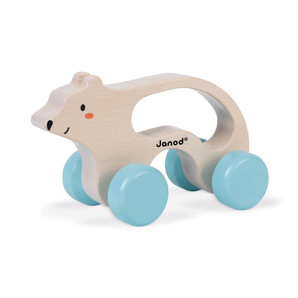 Wooden polar bear toy with blue wheels and a handle to push along. White background.