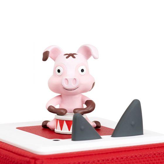 Pink pig beating a drum sitting on top of a red Toniebox.