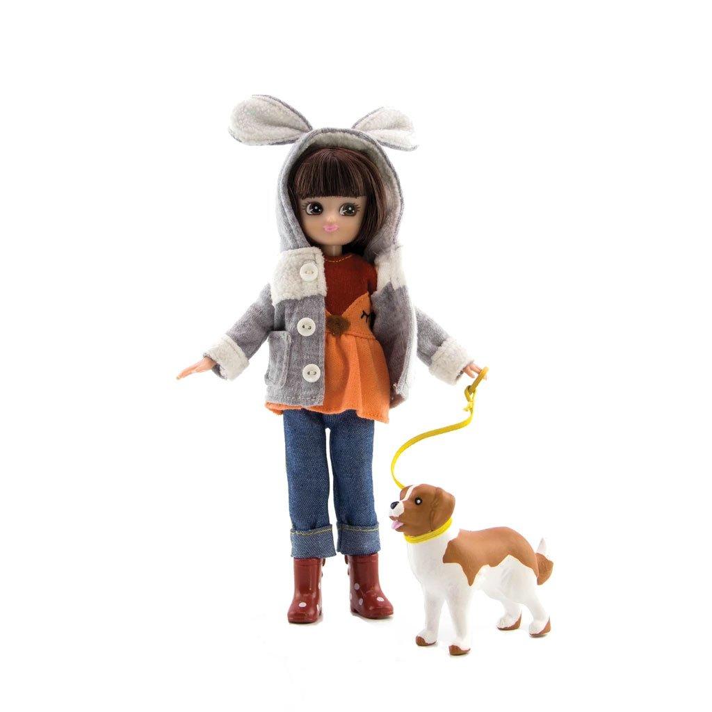 Lottie Doll dressed up for a walk in the park wearing a cute jacket with bunny ears and walking her dog on a lead.