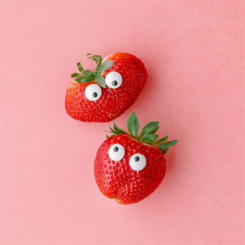 two strawberries with stick-on eyes