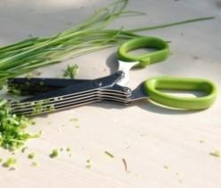 Scissors with lime green handles lying open on the work surface showing the five blades.
