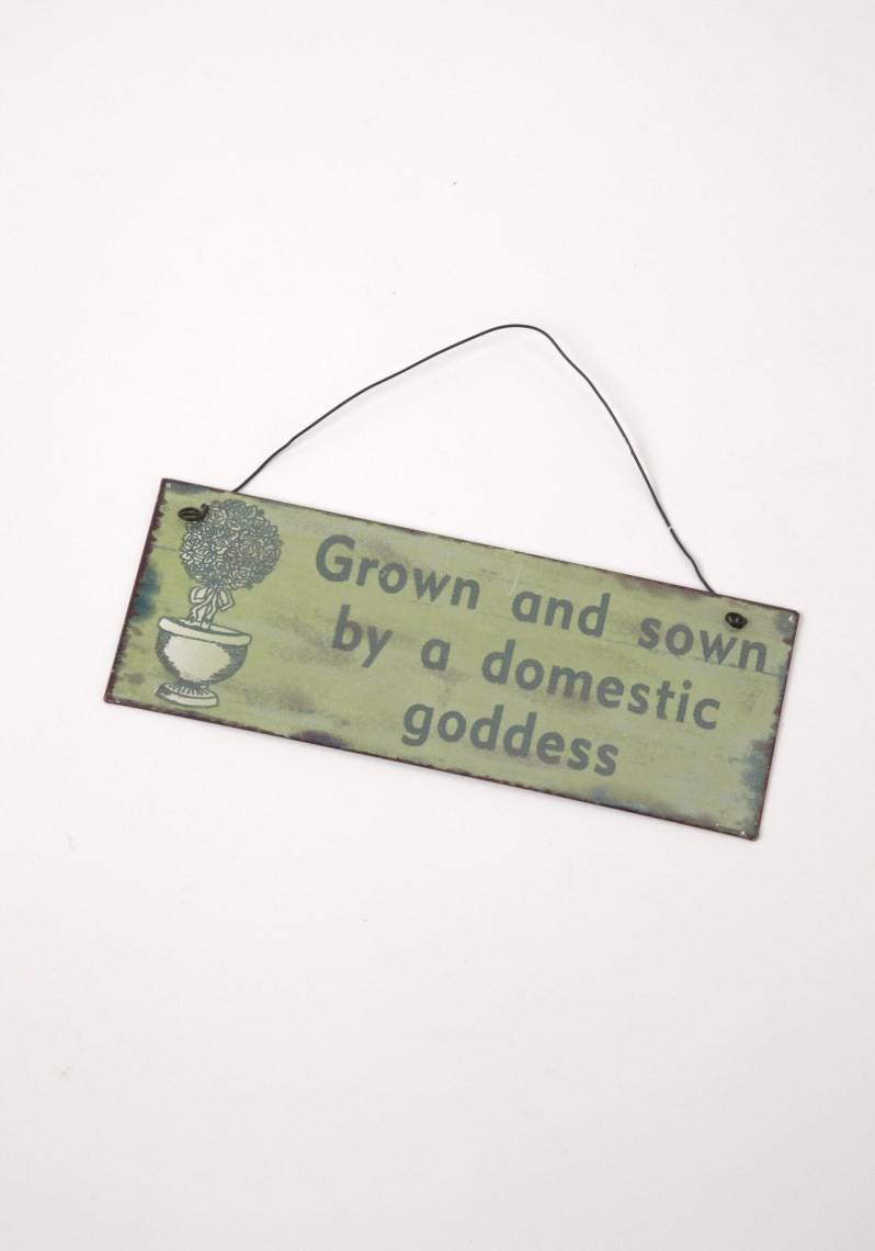 Pale green wooden doorsign on wire hanger with the words 'Grown and sown by a domestic goddess'