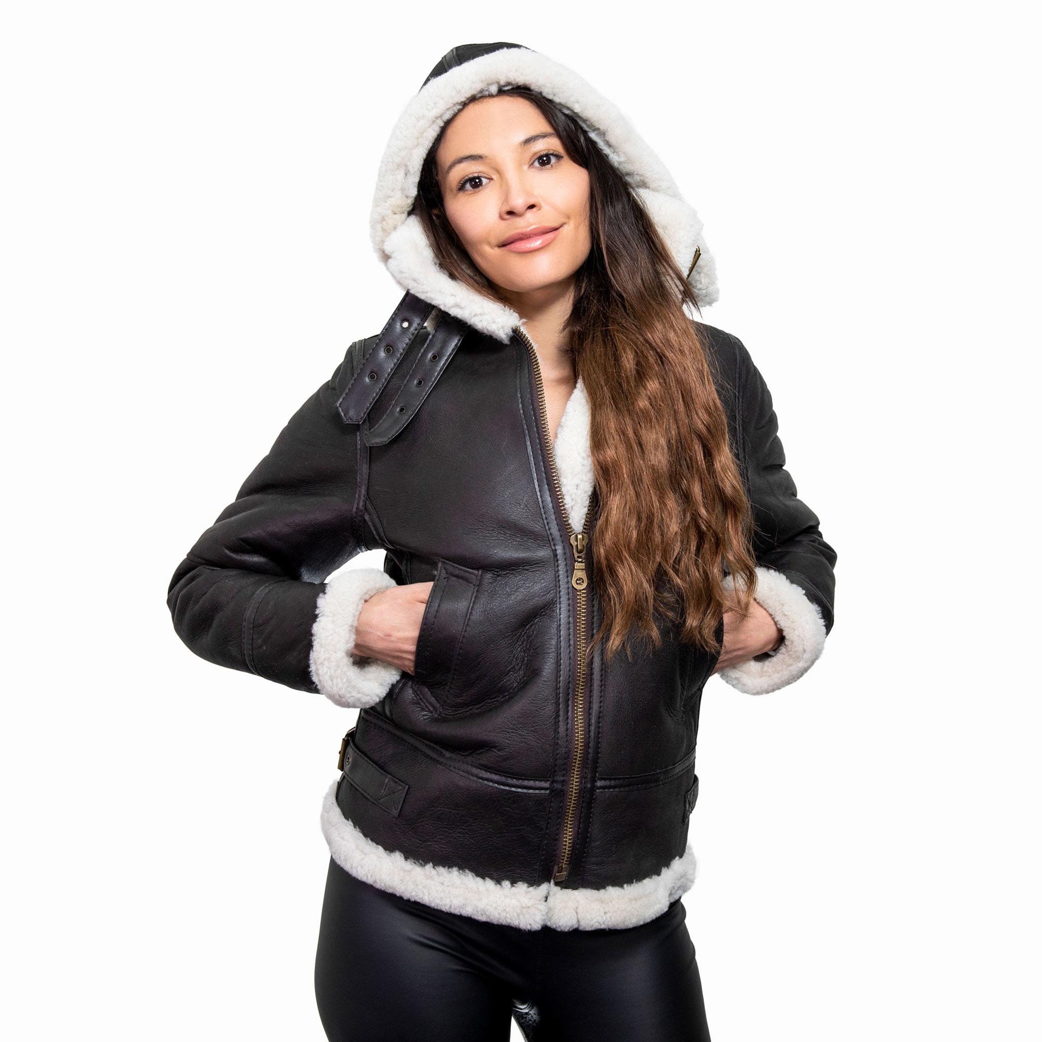 A female model wearing a hooded brown sheepskin jacket, with lush cream inner fur.