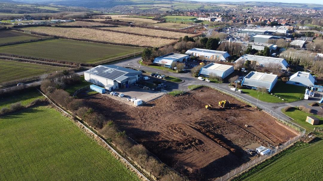 Image displays aerial shot of current Enterprise Way bakery and the footprint of the new build site, surrounded by Whitby business park and fields.