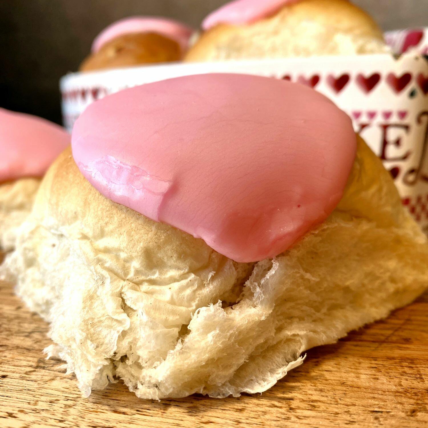Hero shot of a Valentine's Whitby Lemon Bun with pink icing, which is normally white.