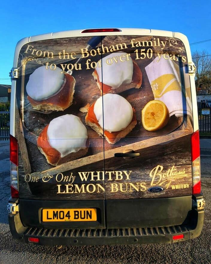 Image of the back of a Botham's delivery van which is wrapped in Whitby Lemon Bun livery and has the number plate: LM04 BUN